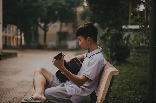 男孩弹吉他的照片photo of boy playing guitar