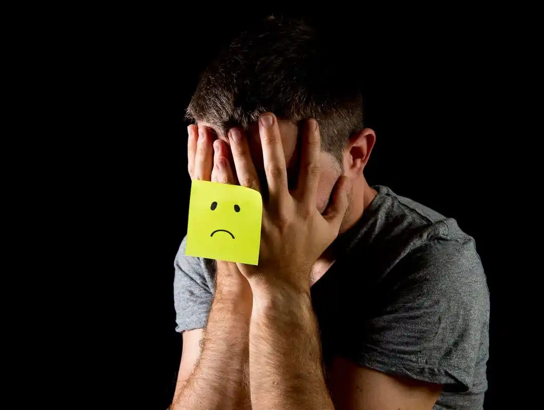 年轻人抑郁独自一人坐在痛苦和悲伤绝望与黄色贴注失败烦躁恼火烦躁